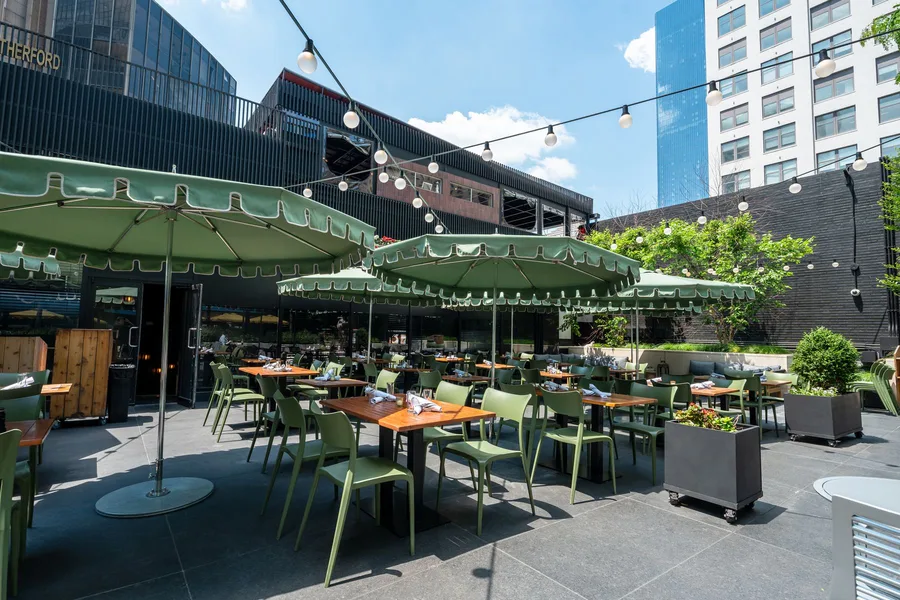 The Rutherford's rooftop patio, string-lit with the Midtown skyline behind it